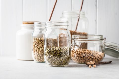 various legumes beans, chickpeas, buckwheat, lentils in glass jars on a white background healthy vegetarian food, vegetable protein, plant based diet concept