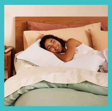 a woman lying in bed with pillows