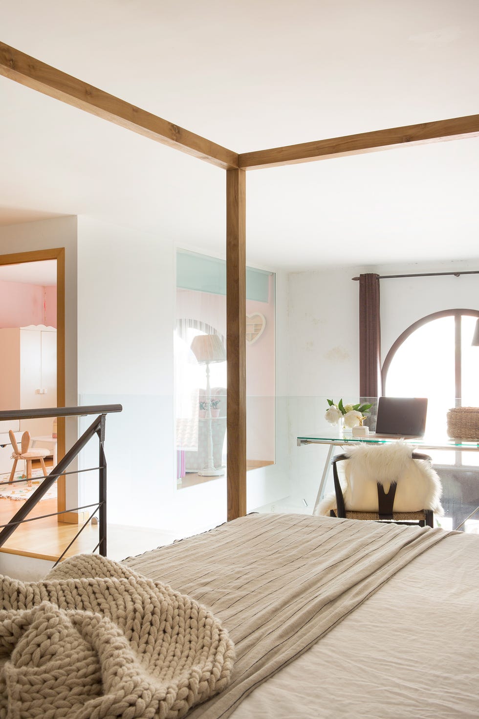 dormitorio con cama con dosel de madera y vistas a la habitación infantil