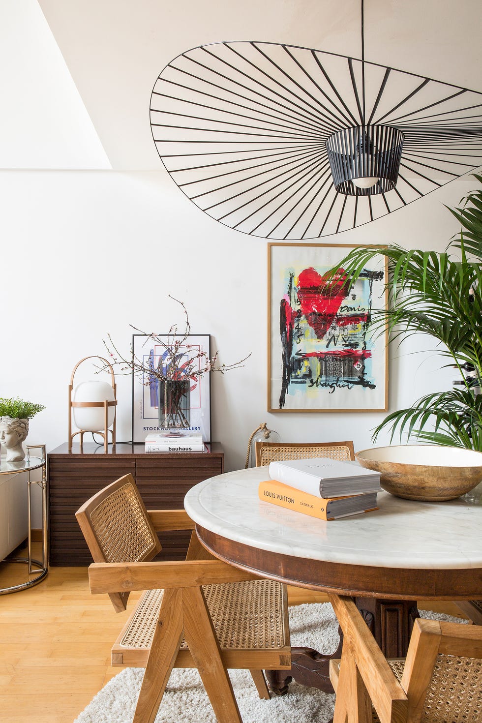 comedor abierto con mesa redonda de herencia y sillas réplicas de la silla chandigarth de pierre jeanneret y le corbusier años 50