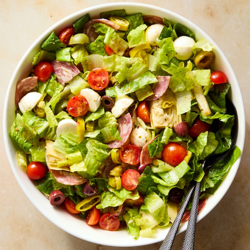 greens with salami, mozzarella balls, artichokes, cherry tomatoes, chopped pepperoncini, and olives