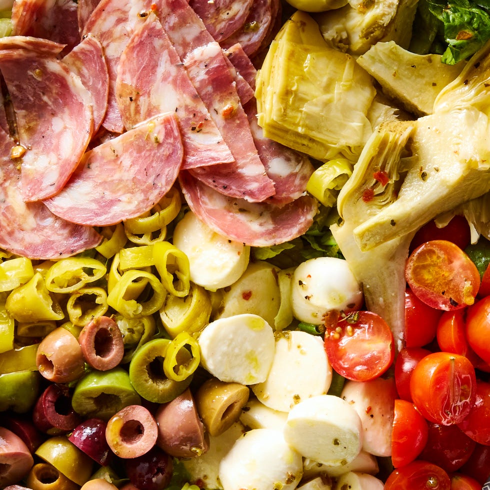 greens with salami, mozzarella balls, artichokes, cherry tomatoes, chopped pepperoncini, and olives