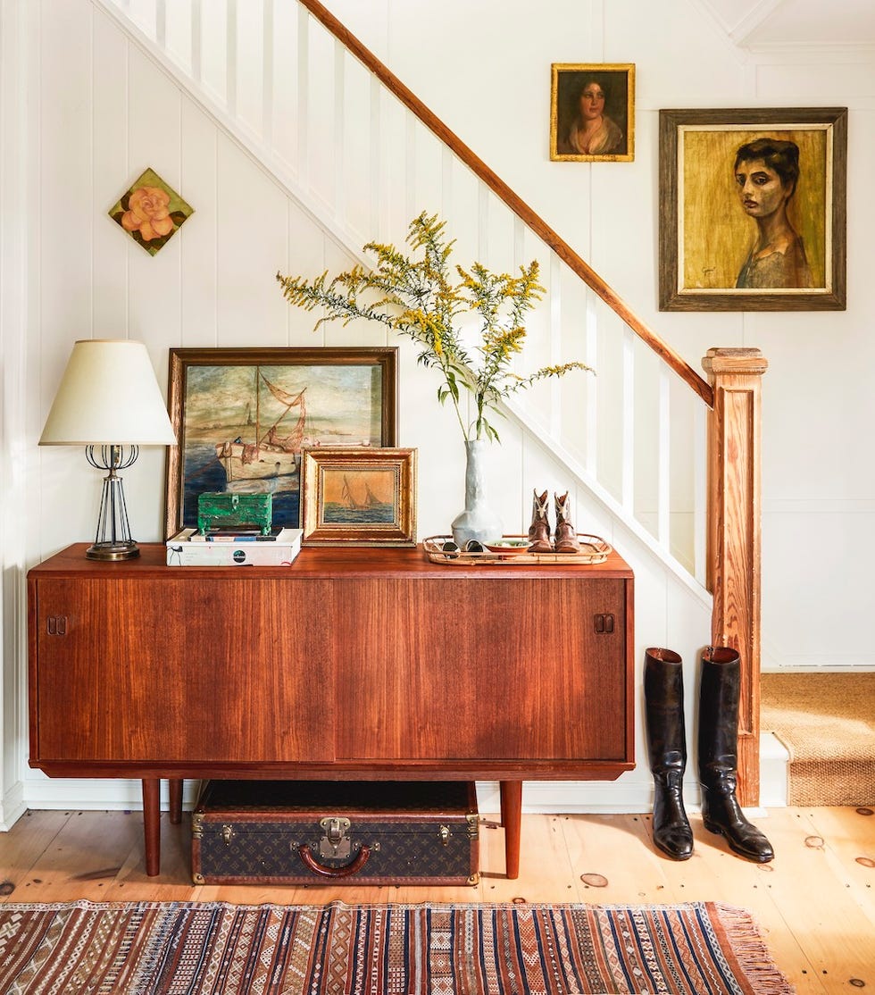 and entryway with a vintage console with collectibles on top of it