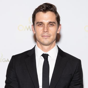 antoni porowski with a stern facial expression, wearing a black suit