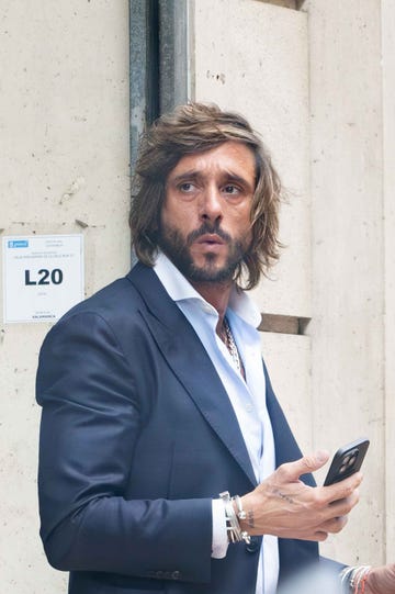 person standing against a wall interacting with a smartphone