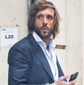 Antonio Revilla person standing against a wall interacting with a smartphone