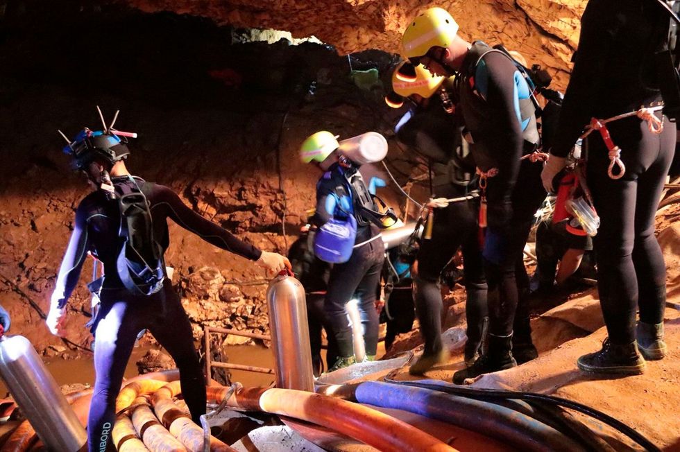 Thaise reddingswerkers onderzoeken een van de grotkamers van het uitgestrekte onderaardse stelsel van Tham Luang De grot liep vol water als gevolg van zware moessonregens en het team bouwde een uitgebreid systeem van pompen op om het waterpeil in de grot zo laag mogelijk te houden