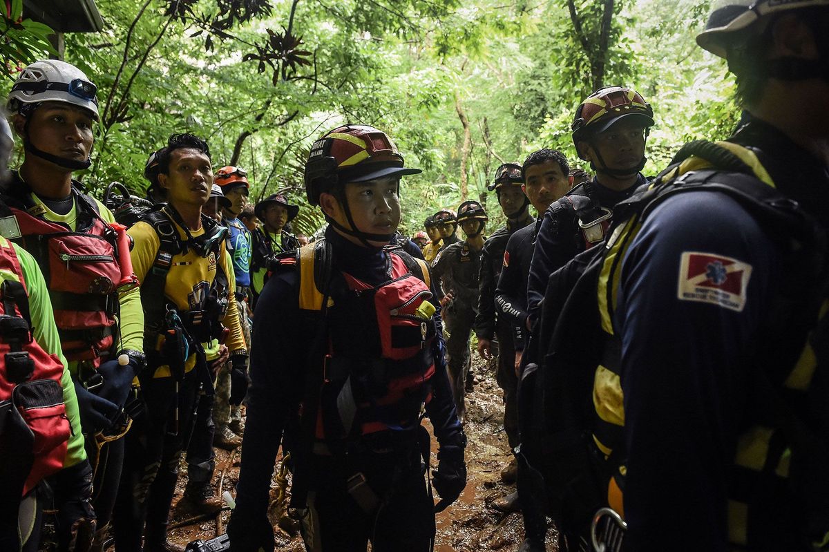 Thaise reddingswerkers en vrijwilligers uit de hele wereld zijn bijeengekomen voor de ingang van het grotstelsel van Tham Luang om de reddingsoperatie te cordineren Tot de groep behoorden grotduikers medici ingenieurs rotsklimmers en talloze andere professionals