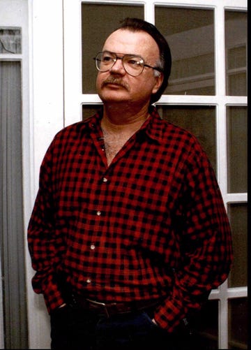a man with glasses and a red and black plaid shirt