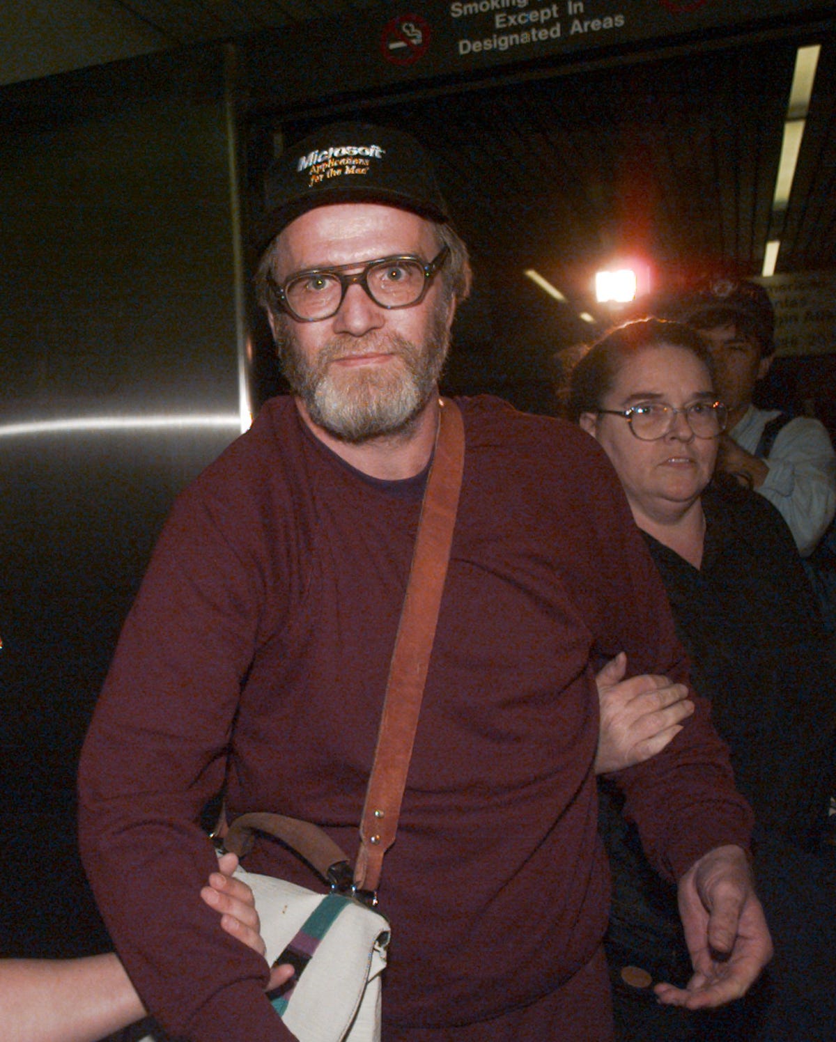 james w. lewis is escorted through boston's logan airport after being released from the federal correctional institution in oklahoma on friday october 13, 1995. lewis served more than 12 years for attempting to extort money from the makers of the tylenol during the 1982 cyanide tampering murders. seven people were killed by cyanide tainted extra tylenol capsules purchased from drug stores and groceries in the chicago area in 1982. the killer was never identified. lewis was a prime suspect but was never charged with the deaths. woman behind lewis is unidentified. (ap photo/charles krupa)