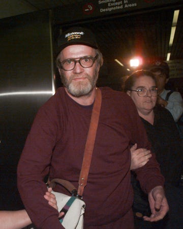 james w. lewis is escorted through boston's logan airport after being released from the federal correctional institution in oklahoma on friday october 13, 1995. lewis served more than 12 years for attempting to extort money from the makers of the tylenol during the 1982 cyanide tampering murders. seven people were killed by cyanide tainted extra tylenol capsules purchased from drug stores and groceries in the chicago area in 1982. the killer was never identified. lewis was a prime suspect but was never charged with the deaths. woman behind lewis is unidentified. (ap photo/charles krupa)