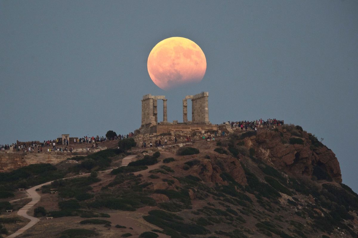 A partial lunar eclipse rises above the fifth century BC Temple of Poseidon at Cape Sounio south of Athens Greece on August 7 2017