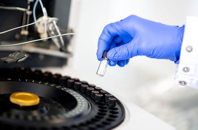 De wetenschappelijk directeur van het bedrijf Corat Therapeutics haalt een glazen flesje uit een analytisch apparaat dat wordt gebruikt om de puurheid en kwaliteit van preparaten vast te stellen De biotechnologische firma ontwikkelt een medicijn tegen COVID19