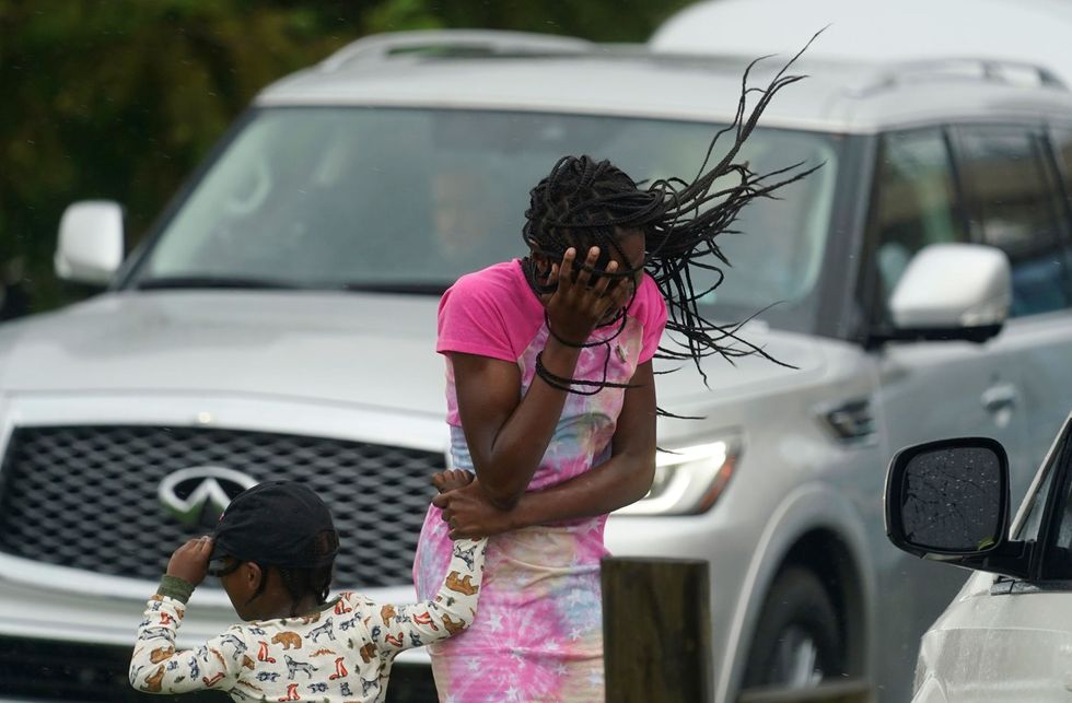 In New Orleans Louisiana beschut een meisje haar gezicht tegen de harde wind en de regen die hurricane Ida met zich meebrengt