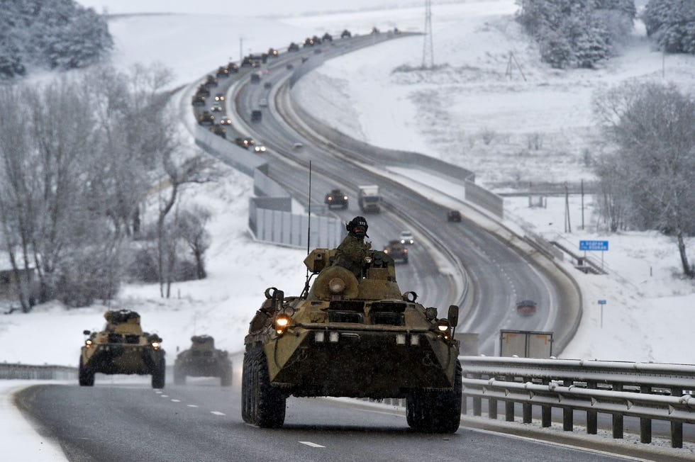 Een konvooi van Russische gepantserde voertuigen rijdt langs een snelweg op de Krim Voordat de invasie serieus begon werd een groot aantal militairen van naar schatting 100000 Russische troepen nabij de Oekraense grens waargenomen maar Moskou ontkende plannen te hebben om een aanval uit te voeren