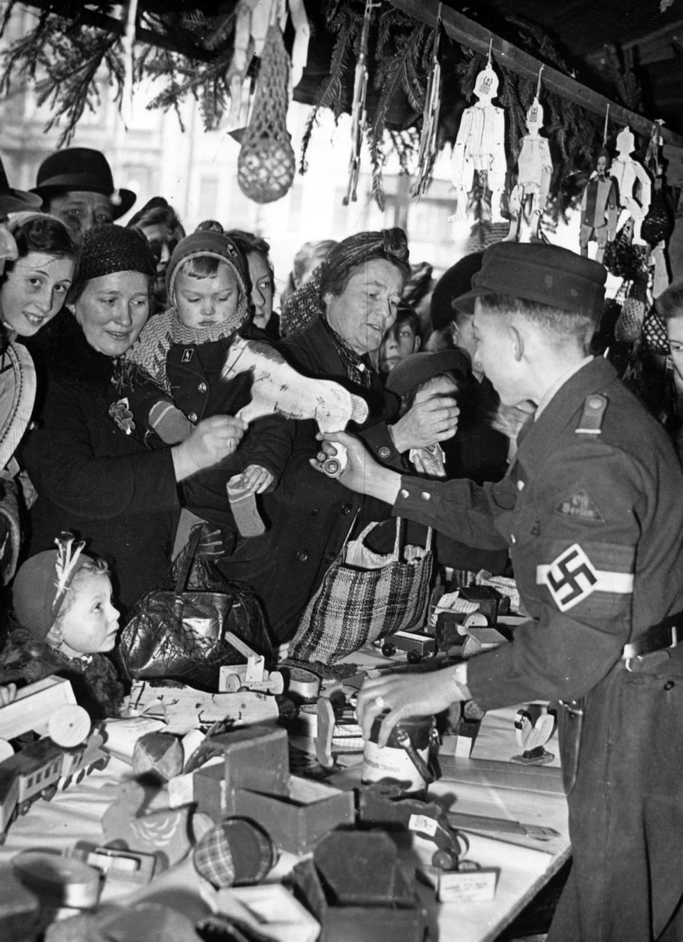 Leden van de Hitlerjugend verkopen zelfgemaakt speelgoed op een kerstmarkt in Berlijn in december 1943 De kerstmarkten in Berlijn en andere steden waren aan het wegkwijnen totdat de NSDAP ze weer leven inblies Het doel was hiermee de economie te stimuleren en tegelijkertijd te zorgen voor een gevoel van trots voor de unieke Duitse tradities