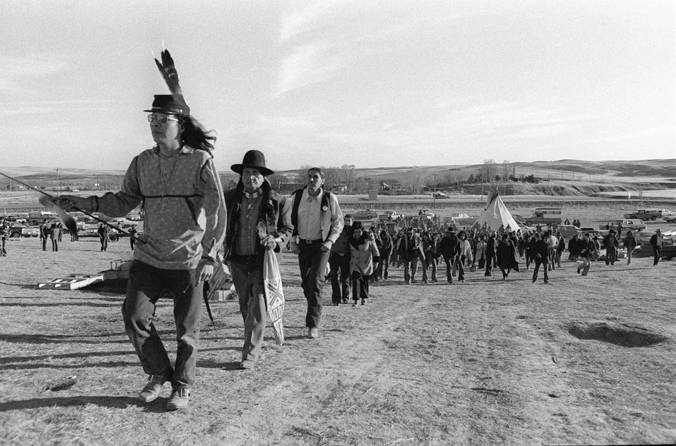 Wounded Knee werd een symbool voor inheemse Amerikanen In 1973 werd de vallei in South Dakota bezet door activisten waardoor het tot schermutselingen kwam met de federale autoriteiten Op deze foto zijn leden van de Oglala Siouxstam te zien die naar de begraafplaats lopen waar hun voorouders na de massamoord werden begraven