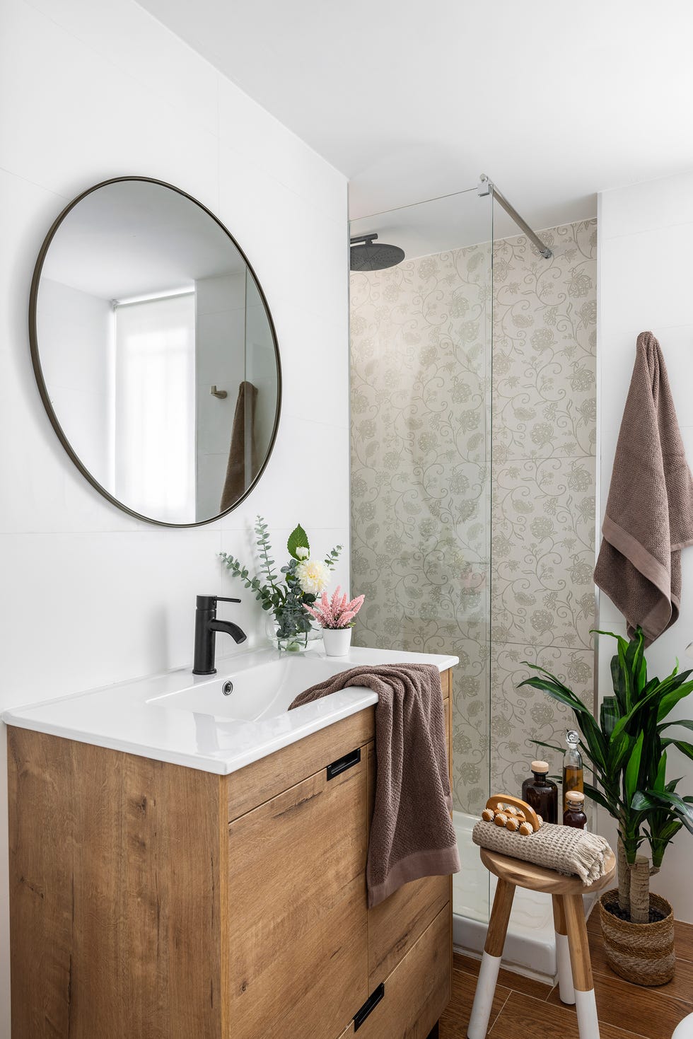 baño con mueble de madera y ducha con azulejos florales