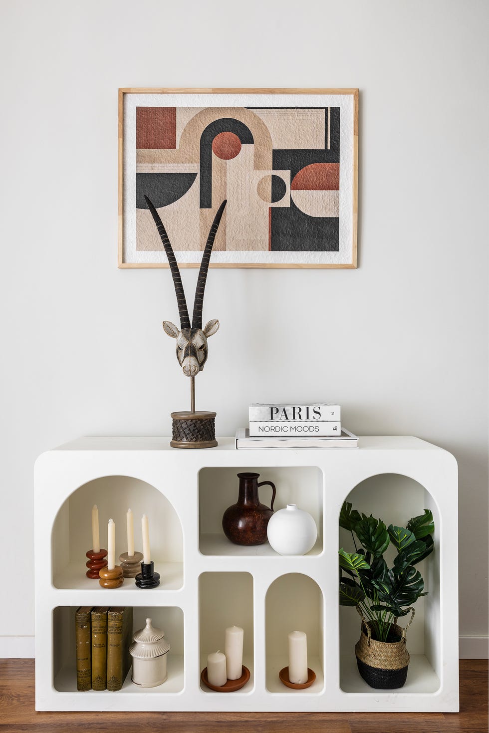 estantería blanca baja con objetos decorativos