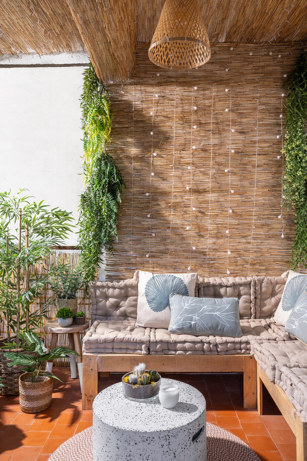 terraza con sofá de madera y mesa de centro redonda de terrazo