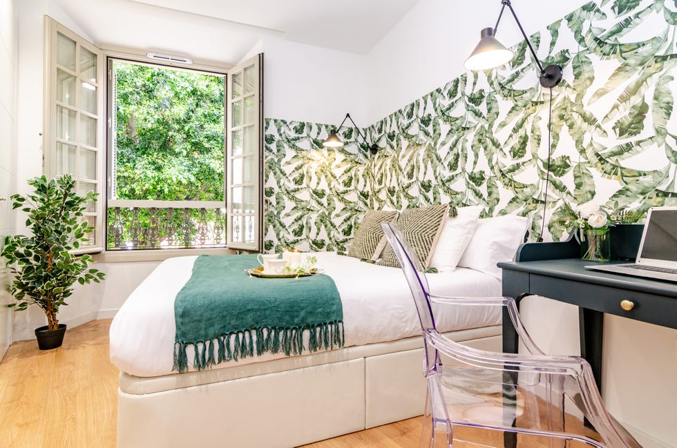 dormitorio con escritorio y pared decorada con papel pintado botánico