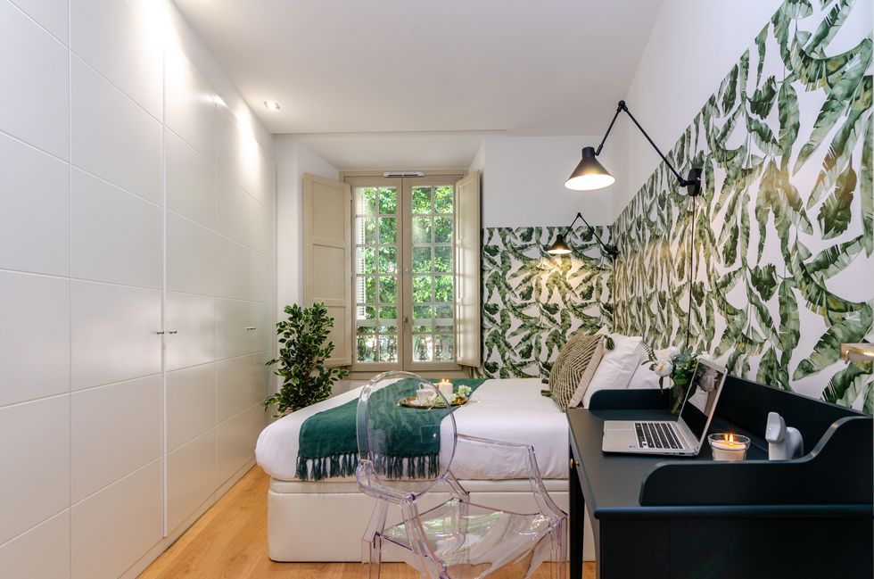 dormitorio con escritorio y pared decorada con papel pintado botánico