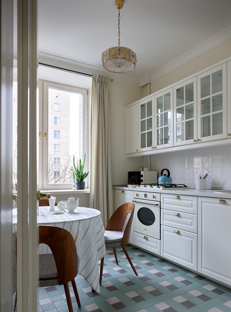 cocina de estilo retro con armarios en blanco y suelo de baldosas geométricas