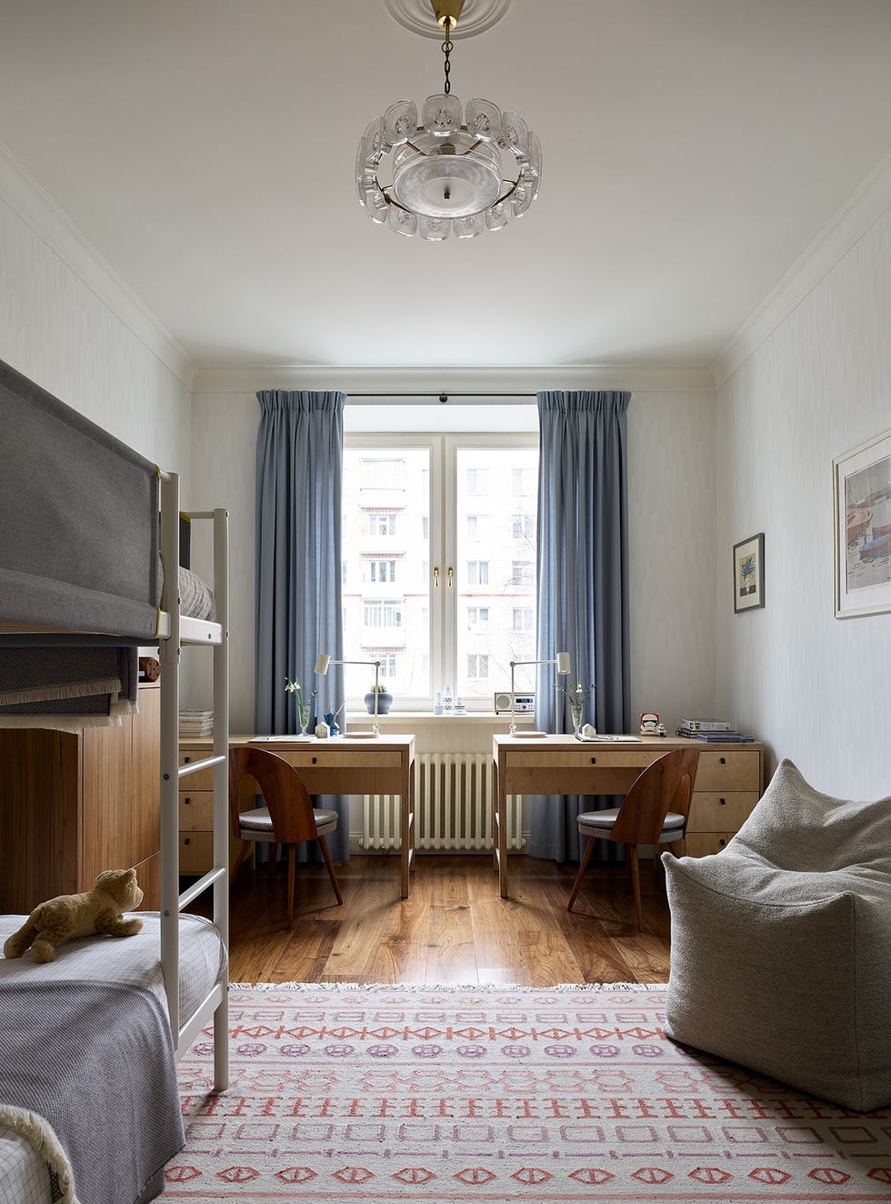 habitación infantil con literas y escritorios decorada en tonos neutros