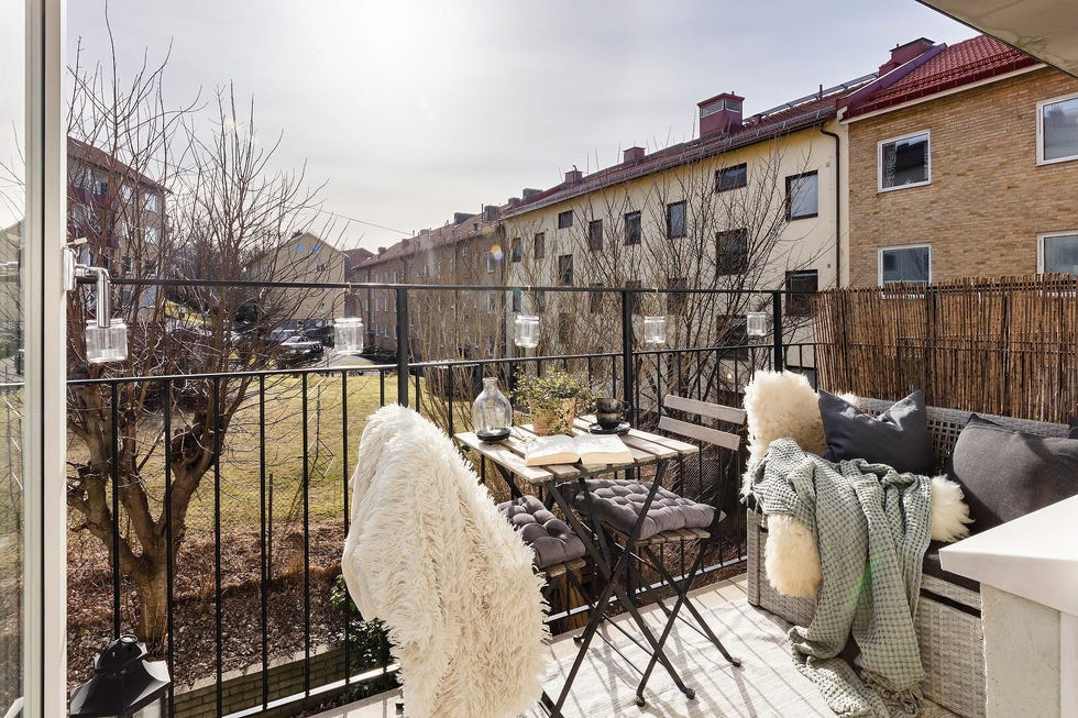 terraza de estilo nórdico con mesa y sillas plegables y banco como rincón de lectura