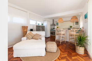 salón con cocina decorado en blanco y azul con fibras naturales
