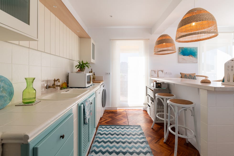 cocina con barra y armarios blancos y azules