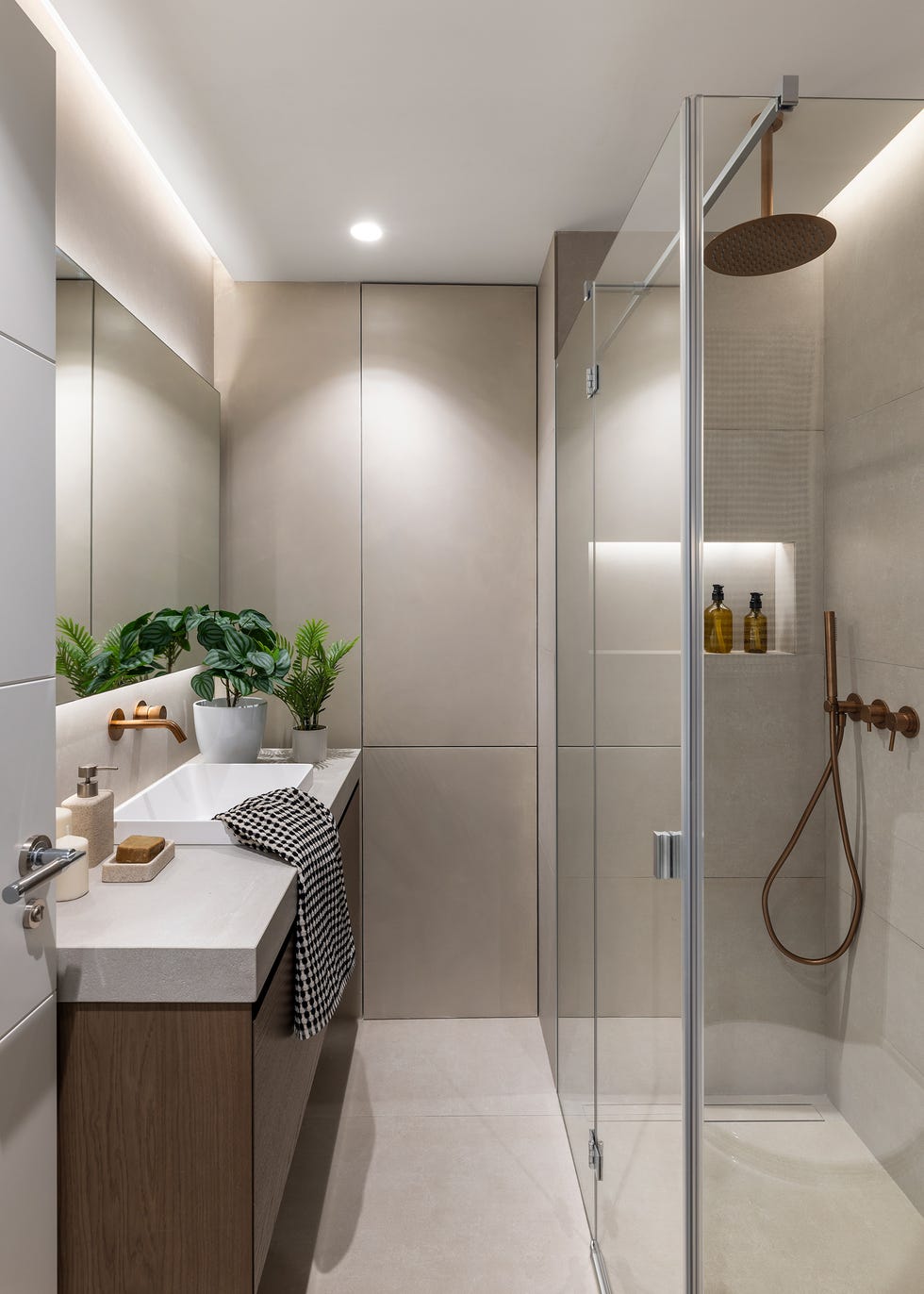 baño con ducha y mueble volado de madera