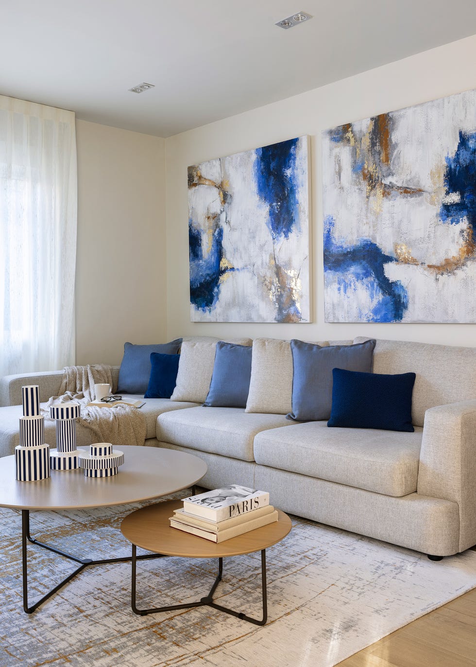 sofá con chaiselongue beige y mesas de centro redondas
