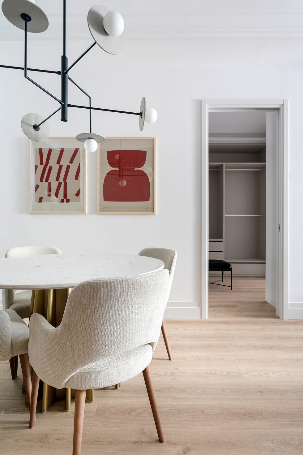 mesa de comedor con sobre de mármol y redondo y sillas tapizadas en beige