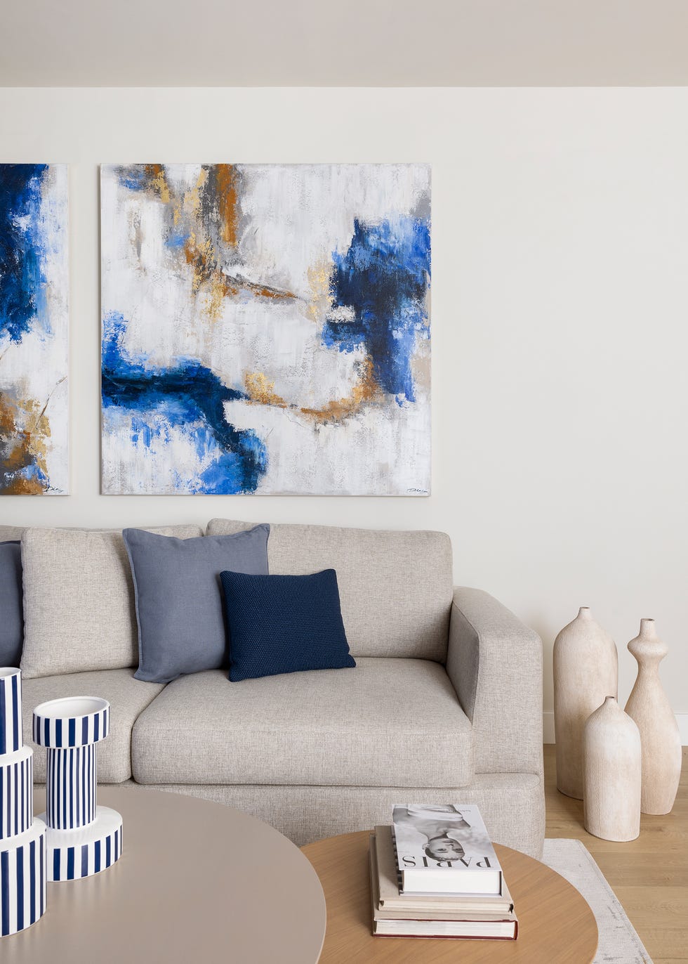 sofá beige y cuadros abstractos en tonos azules