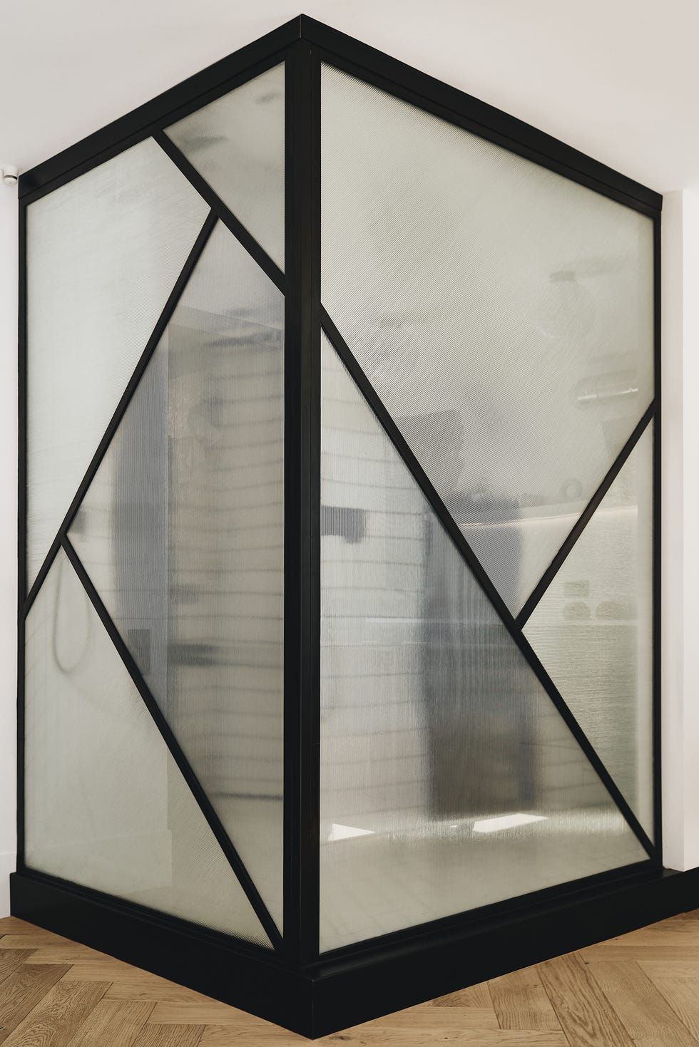 baño con cerramiento de vidrio y acero negro