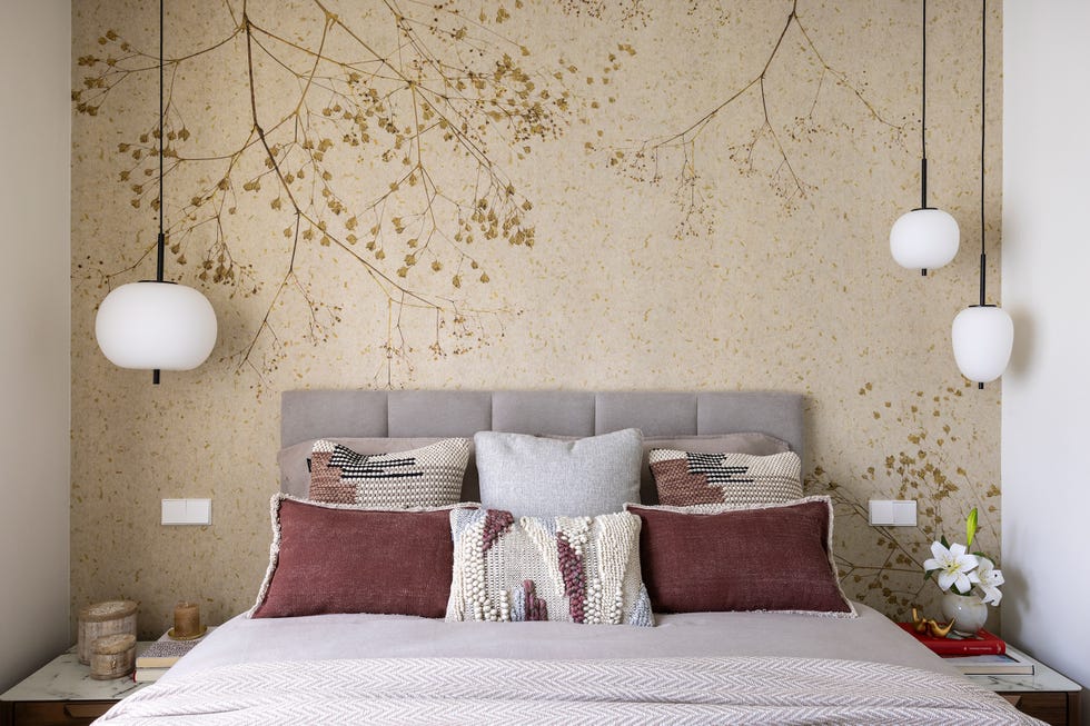dormitorio con papel pintado floral y cabecero tapizado gris