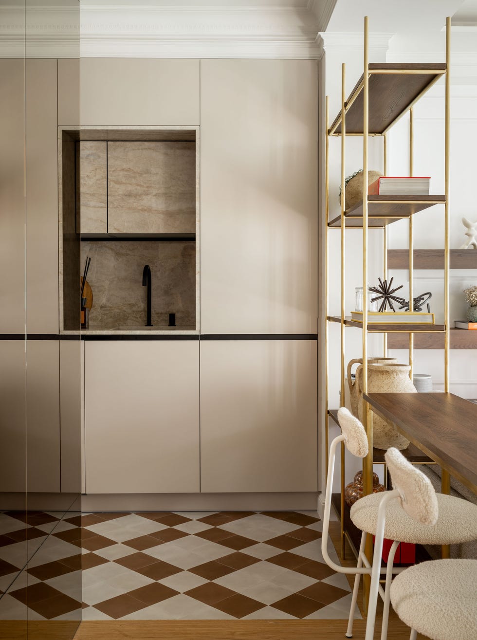 cocina con armarios sin tiradores en color beige y barra de desayunos con taburetes de borreguito