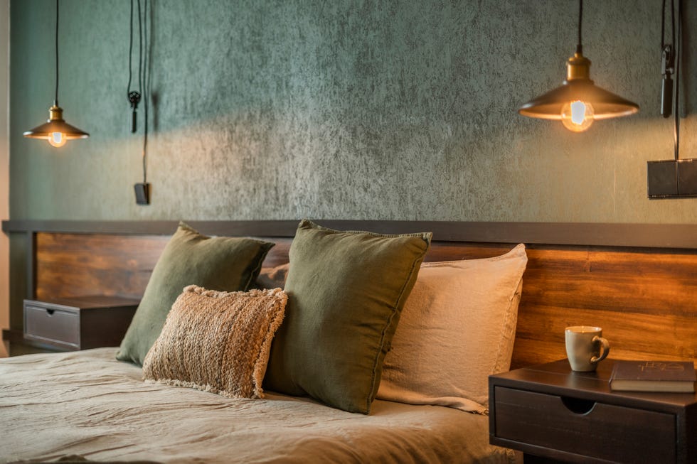 dormitorio con cabecero de madera a medida y pared con papel pintado verde