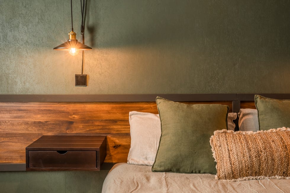 dormitorio con cabecero de madera a medida y pared con papel pintado verde