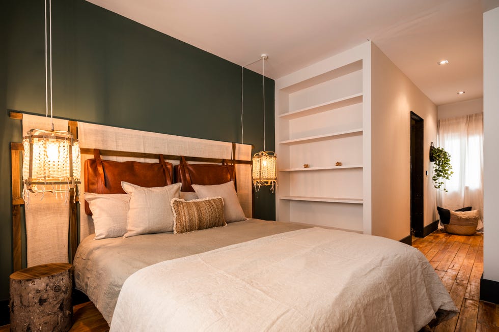 dormitorio de estilo jungle decorado en blanco y verde con muebles de madera y fibras