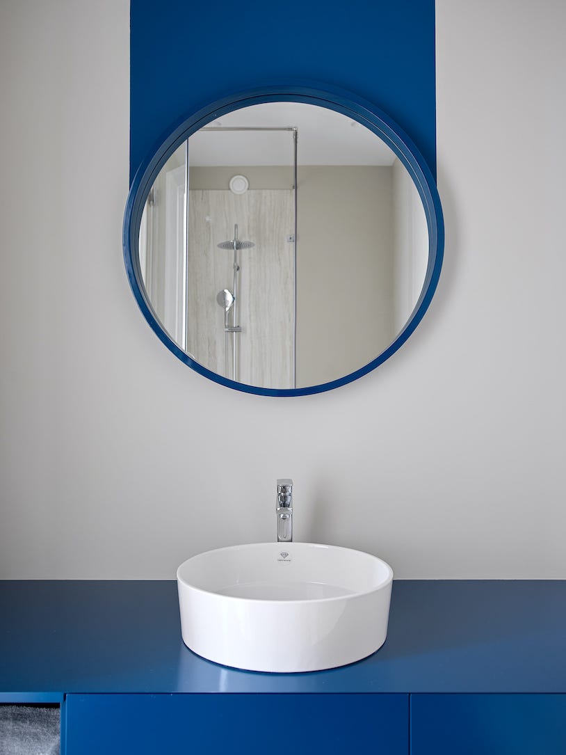 baño moderno con espejo y mueble de lavabo azul