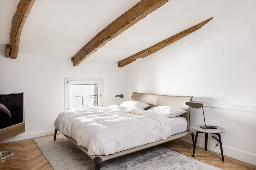 dormitorio abuhardillado con vigas vistas de madera