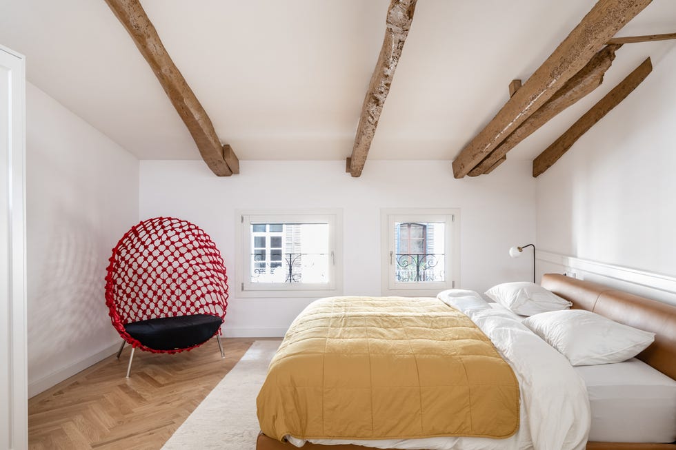 dormitorio abuhardillado con vigas vistas de madera