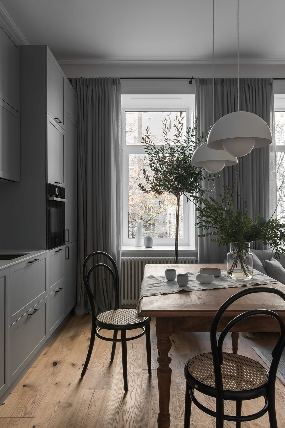 cocina gris y comedor integrados en el salón con muebles rústicos y modernos