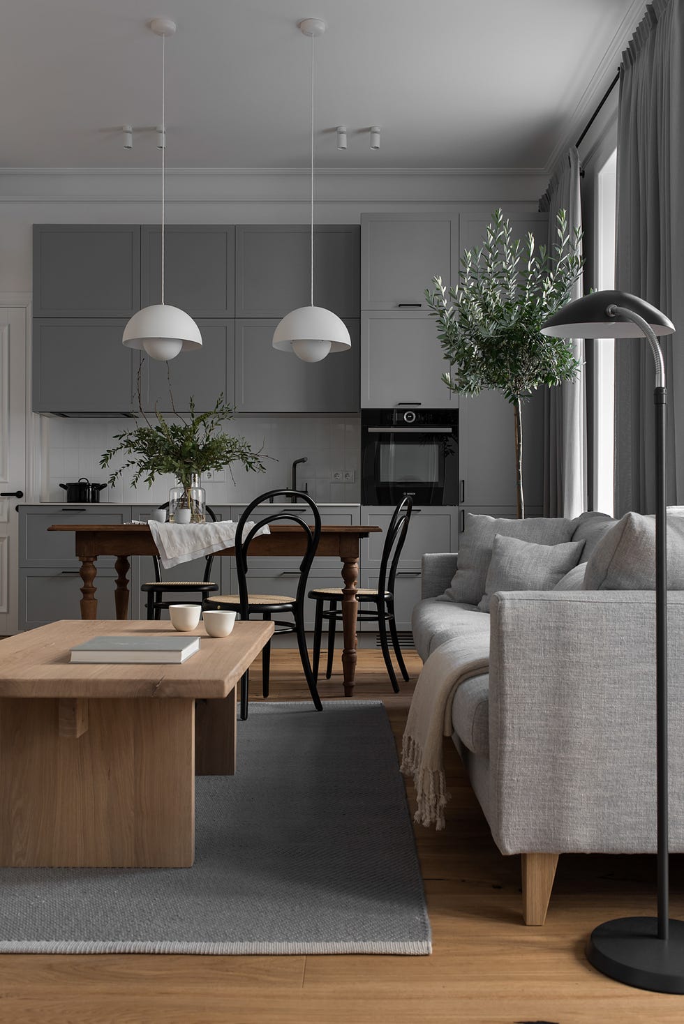 salón con comedor y cocina decorado en gris