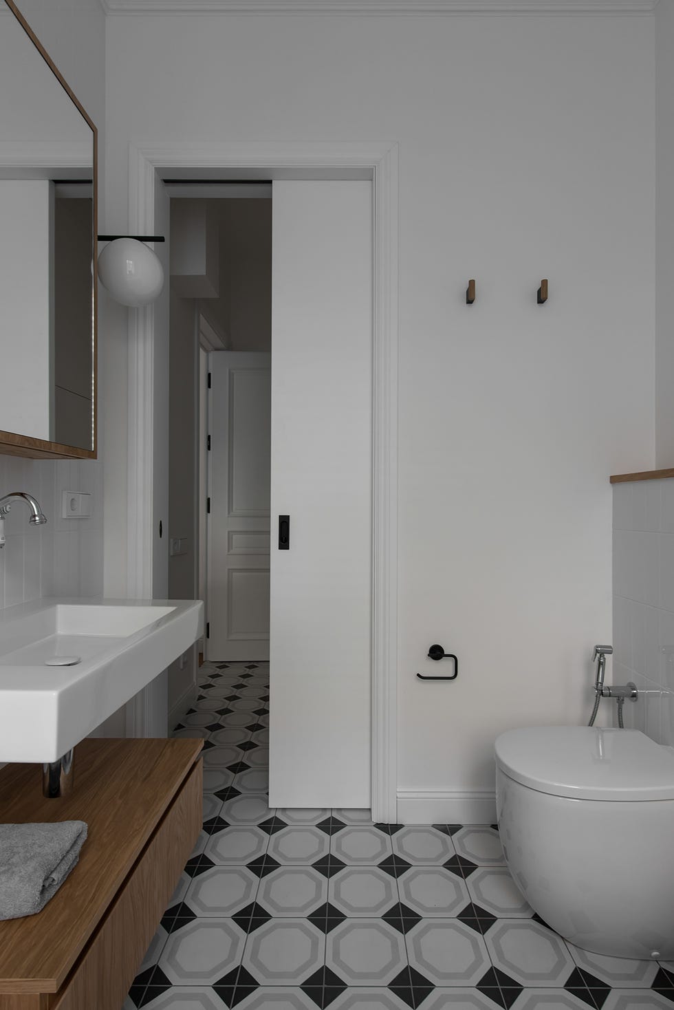 baño moderno con suelo de baldosas geométricas y puerta corredera