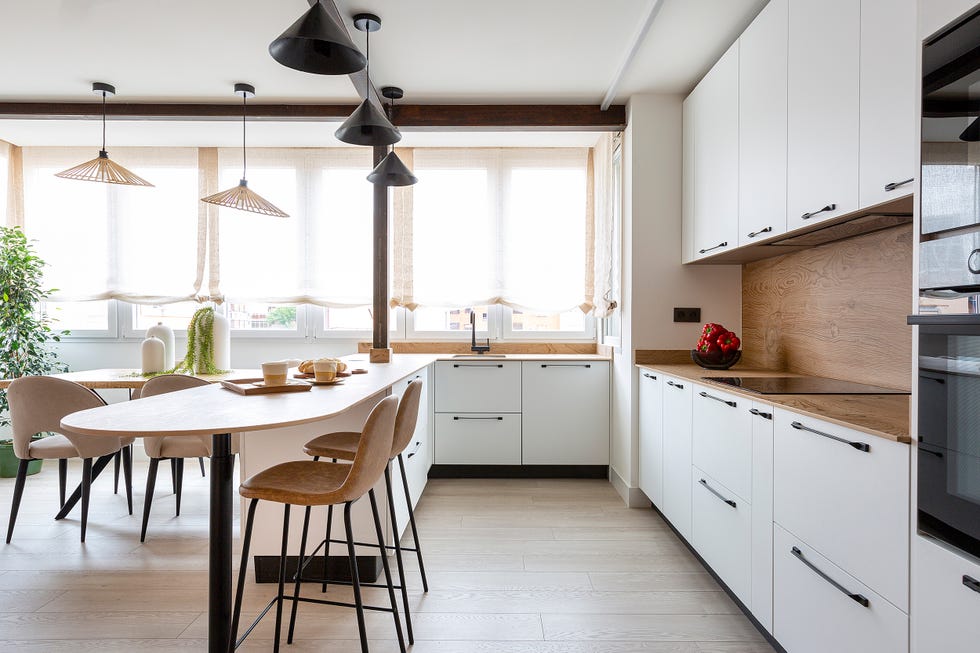 cocina blanca con barra integrada en el salón