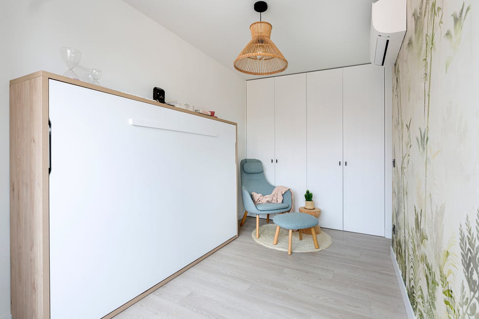 habitación con cama abatible y papel pintado botánico
