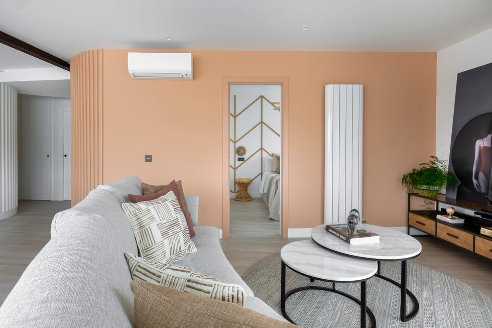 salón moderno con sofá gris y pared naranja